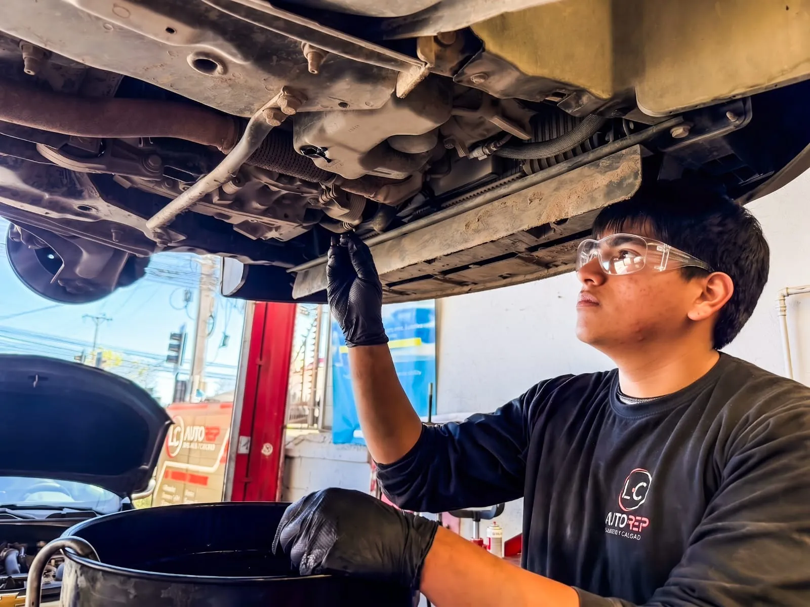 Técnico trabajando bajo un vehículo